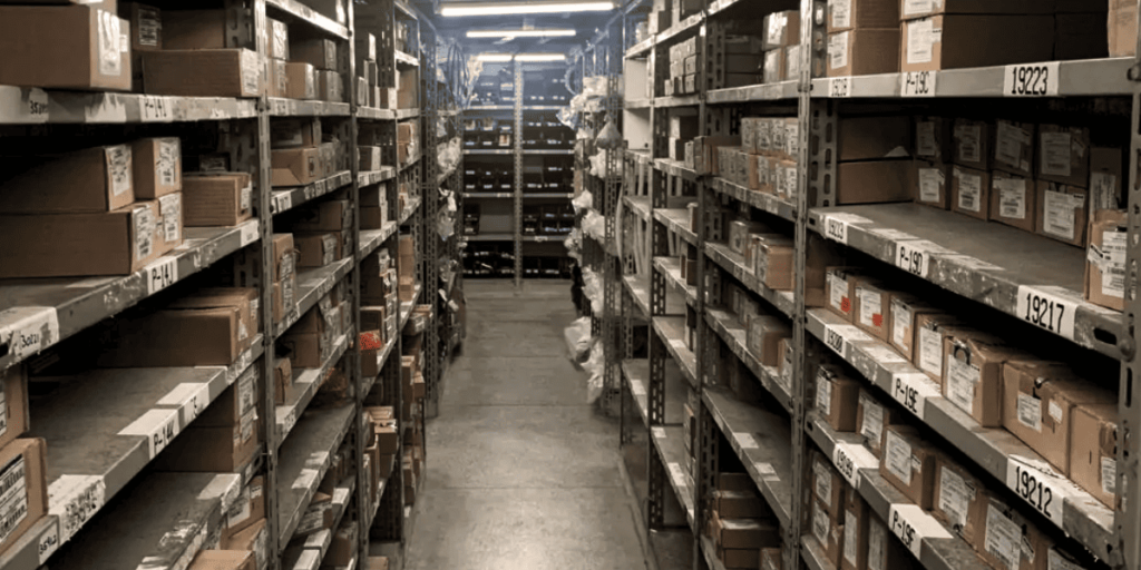 Corredores de prateleiras metálicas com estoque de peças industriais
